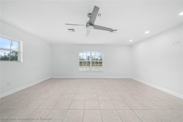 unfurnished room with ceiling fan, a wealth of natural light, and visible vents