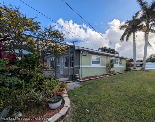 view of front of home featuring an AC wall unit and a front lawn