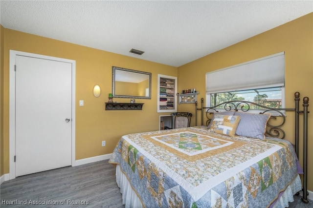 bedroom with wood-type flooring and a textured ceiling