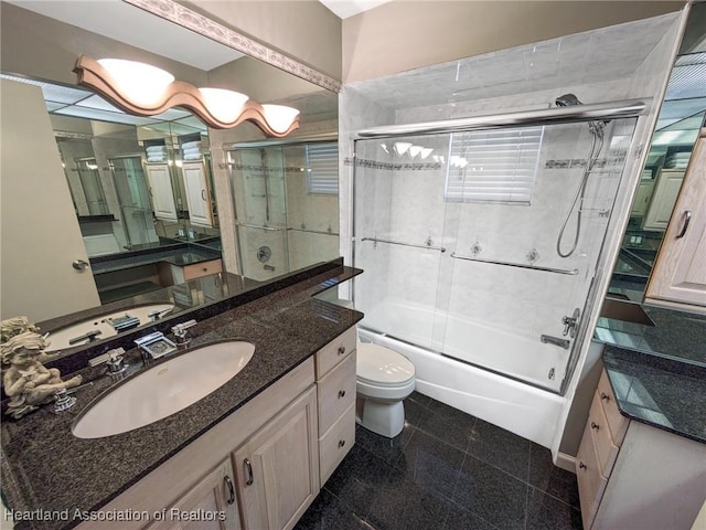 full bathroom with vanity, toilet, and shower / bath combination with glass door