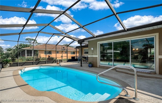 view of swimming pool featuring a patio and glass enclosure