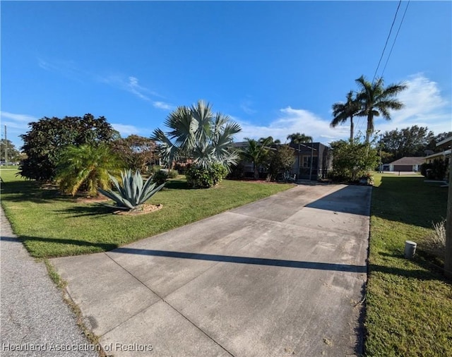 view of property hidden behind natural elements with a front lawn