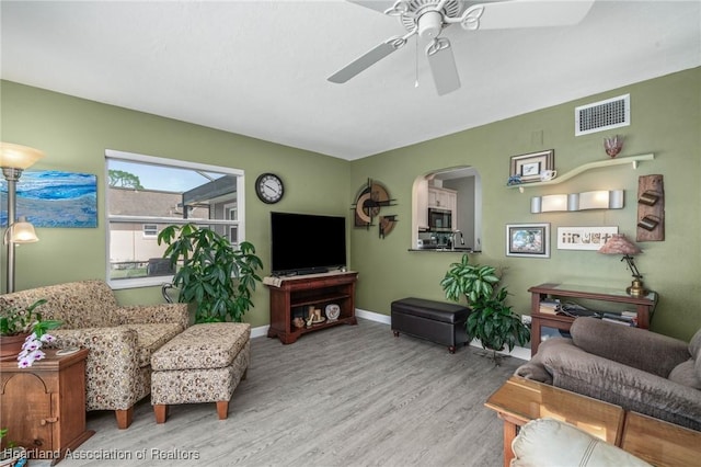 living room featuring ceiling fan and light hardwood / wood-style flooring