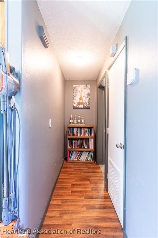 hallway featuring hardwood / wood-style floors and a textured ceiling