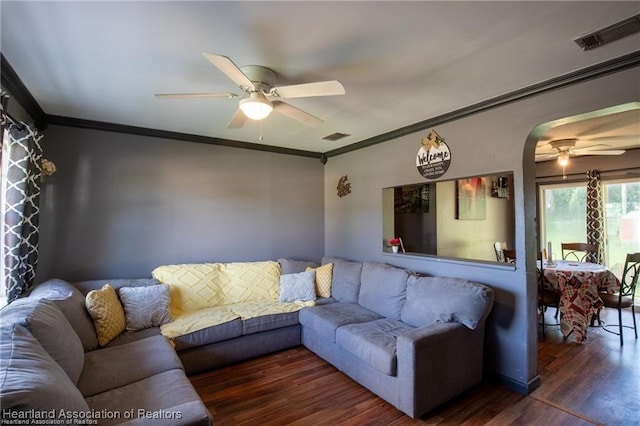 living room featuring dark hardwood / wood-style flooring, crown molding, and ceiling fan