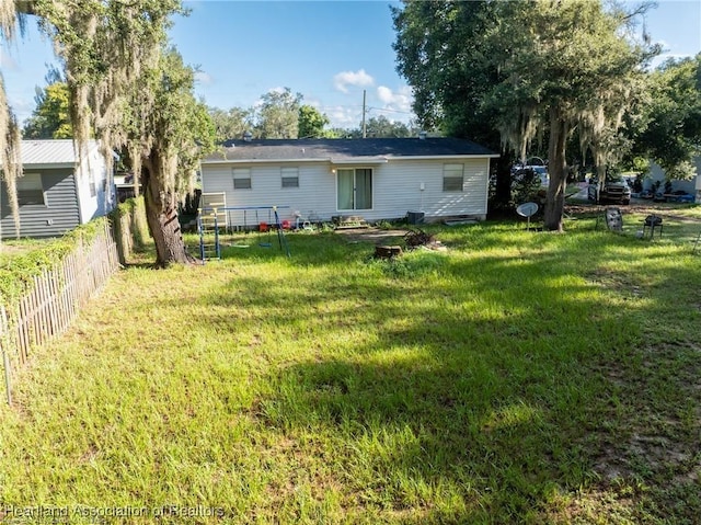 rear view of house featuring a lawn