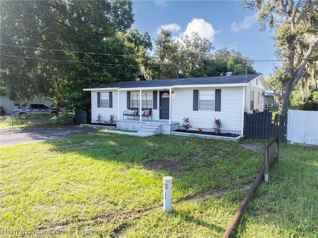 single story home with a front lawn and covered porch