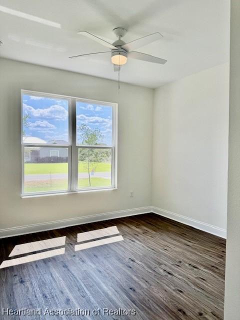 5279 Pebble Dr, Sebring, FL 33872 - unfurnished room featuring baseboards, dark wood finished floors, and ceiling fan