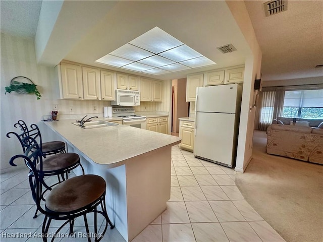 1704 Palm St, Sebring, FL 33870 - kitchen with white appliances, a sink, a kitchen breakfast bar, a peninsula, and light countertops