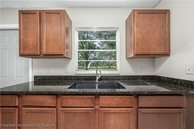 kitchen featuring dark stone counters and sink