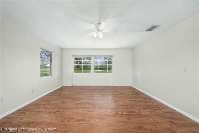 spare room featuring wood-type flooring, a textured ceiling, and ceiling fan