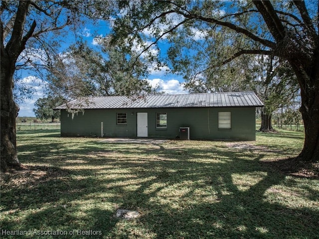 rear view of property featuring a lawn