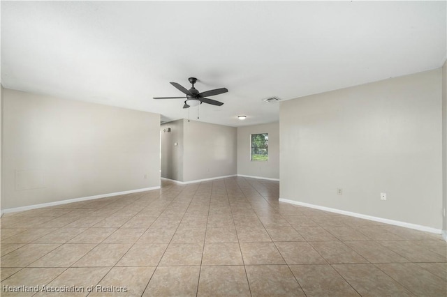 tiled spare room featuring ceiling fan