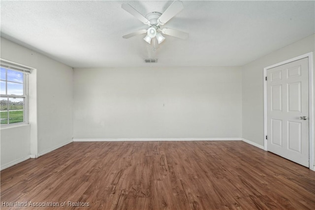 empty room featuring ceiling fan and dark hardwood / wood-style floors