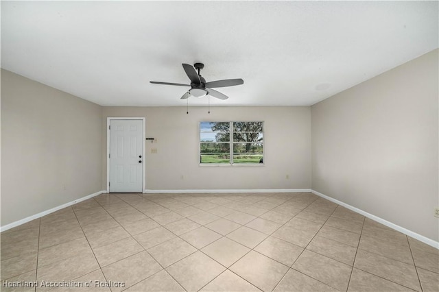 tiled spare room featuring ceiling fan