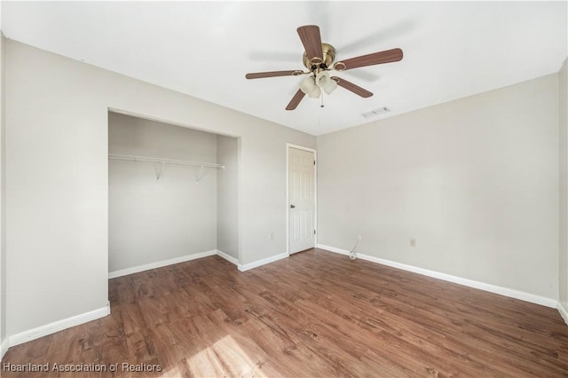 unfurnished bedroom with a closet, hardwood / wood-style flooring, and ceiling fan