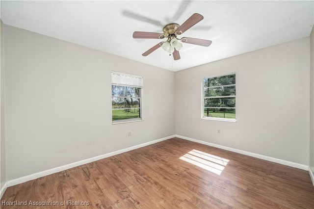 unfurnished room featuring plenty of natural light, ceiling fan, and wood-type flooring