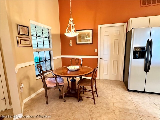 dining room with light tile patterned flooring, visible vents, and baseboards