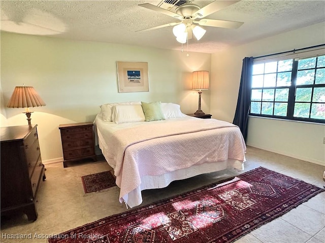 bedroom with visible vents, baseboards, a textured ceiling, and ceiling fan