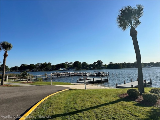 view of dock featuring a yard and a water view