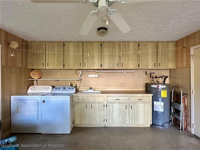 laundry area with washing machine and clothes dryer, a textured ceiling, electric water heater, and a sink