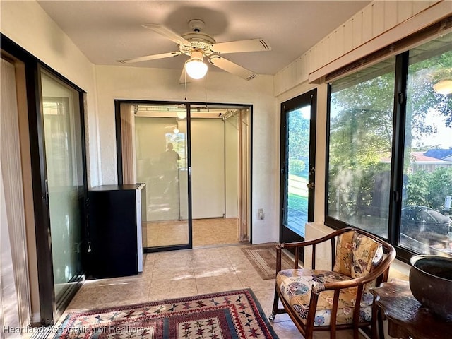 sunroom / solarium featuring a ceiling fan