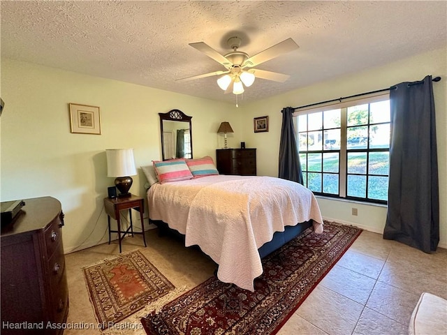 bedroom with a textured ceiling and a ceiling fan