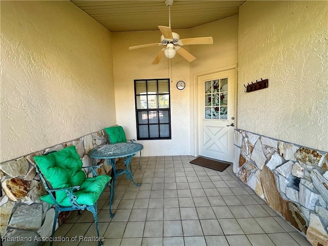 entrance to property with stucco siding and a ceiling fan