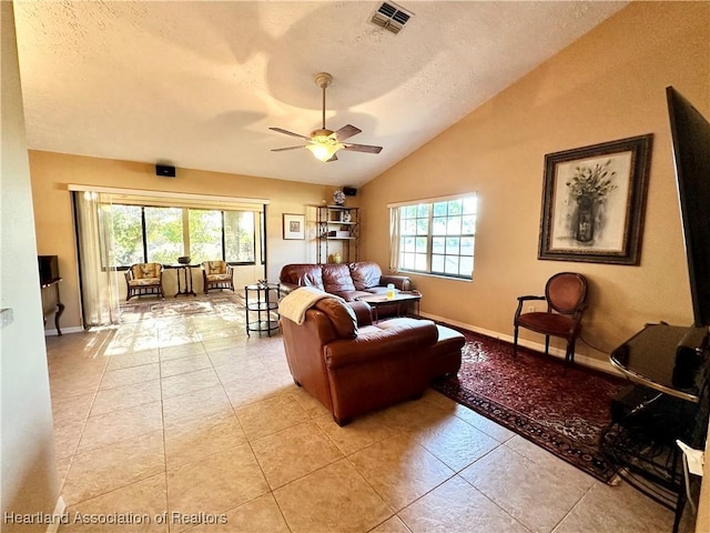 living room with plenty of natural light, a ceiling fan, visible vents, and vaulted ceiling
