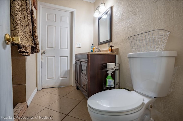 bathroom featuring toilet, tile patterned flooring, vanity, and baseboards