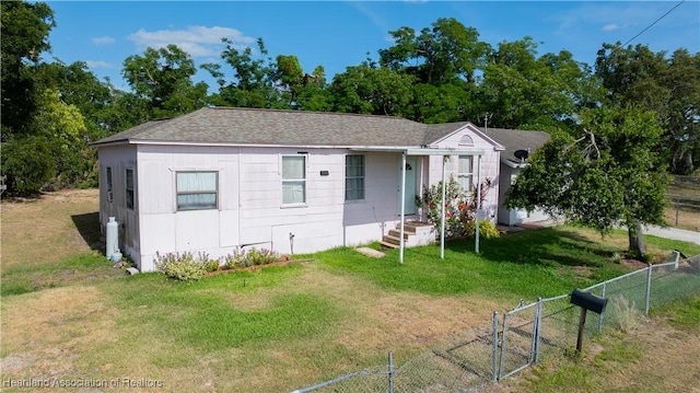 bungalow-style house with a front yard, roof with shingles, and fence