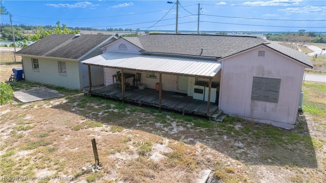 rear view of house featuring metal roof