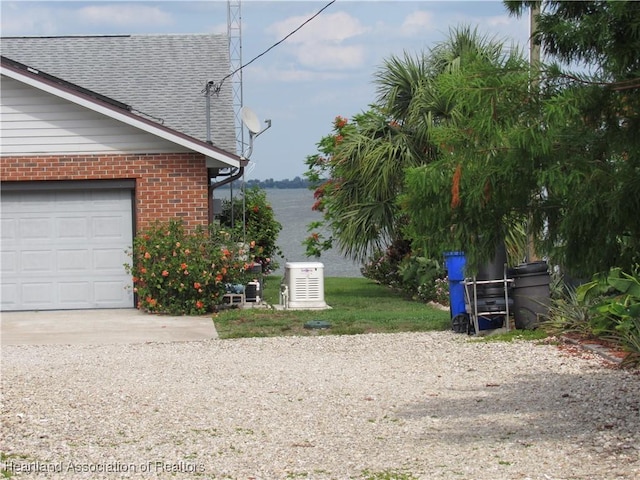 3955 Placid Dr, Lake Placid, FL 33852 - view of side of property featuring brick siding, a shingled roof, concrete driveway, and a garage