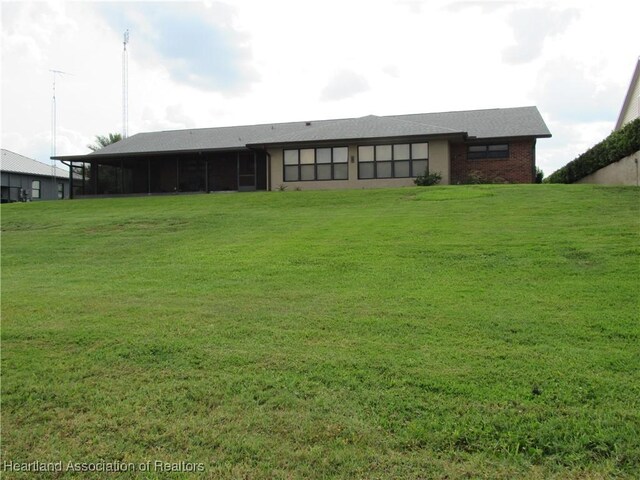 3955 Placid Dr, Lake Placid, FL 33852 - view of front facade with a sunroom and a front yard
