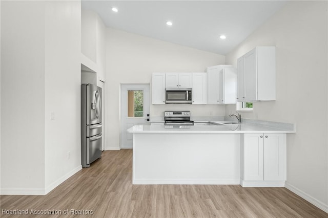 kitchen featuring sink, high vaulted ceiling, kitchen peninsula, white cabinets, and appliances with stainless steel finishes