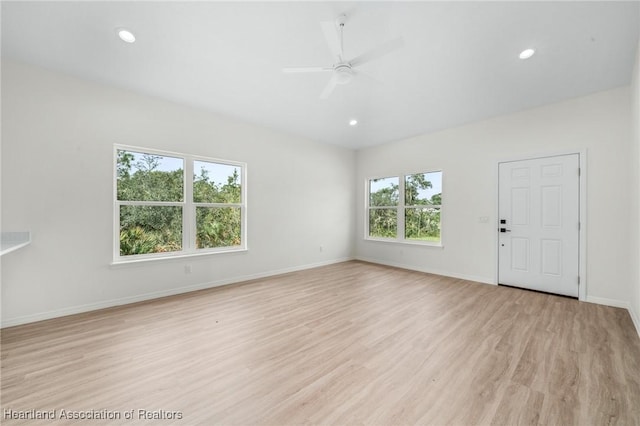 unfurnished living room with ceiling fan, a wealth of natural light, and light hardwood / wood-style flooring