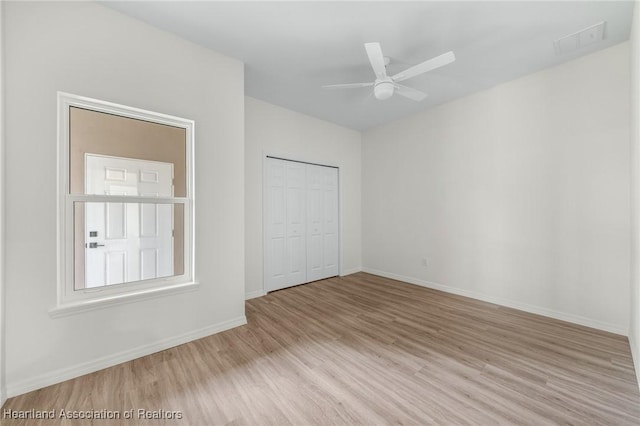 unfurnished bedroom with ceiling fan, light hardwood / wood-style floors, and a closet