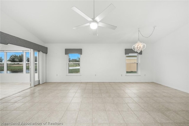 empty room featuring ceiling fan with notable chandelier, lofted ceiling, and light tile patterned floors