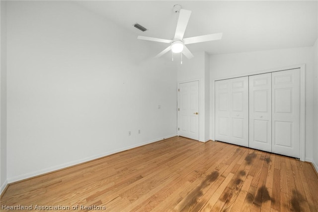 unfurnished bedroom featuring ceiling fan, light wood-type flooring, lofted ceiling, and a closet