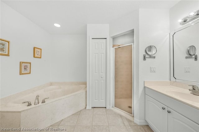 bathroom featuring shower with separate bathtub, vanity, and tile patterned floors