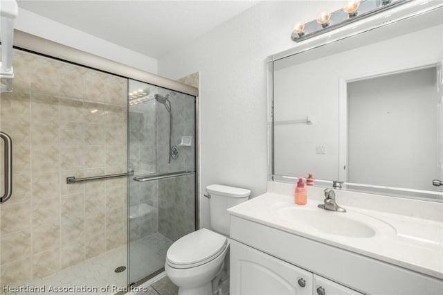 bathroom featuring vanity, an enclosed shower, and toilet