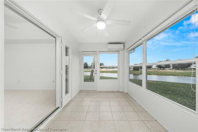 unfurnished sunroom with a wall mounted air conditioner, ceiling fan, and a water view