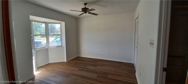 unfurnished room with ceiling fan and dark wood-type flooring