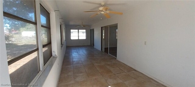 unfurnished sunroom with ceiling fan