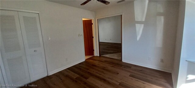 unfurnished bedroom featuring dark hardwood / wood-style flooring, a closet, and ceiling fan