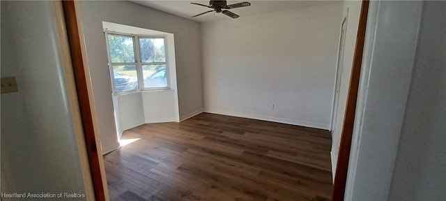 unfurnished room featuring ceiling fan and dark wood-type flooring