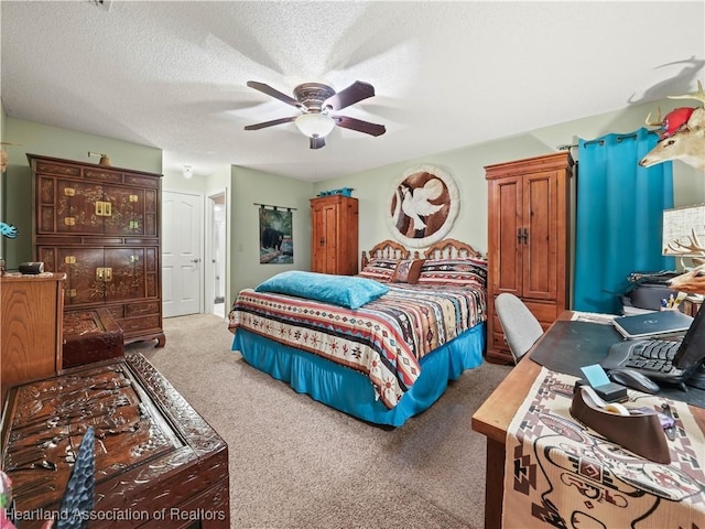 bedroom featuring carpet floors, ceiling fan, and a textured ceiling