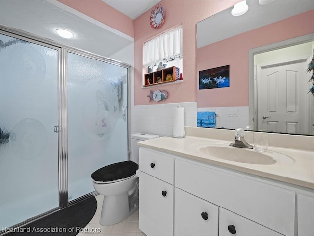 full bath featuring tile patterned floors, a stall shower, tile walls, and vanity