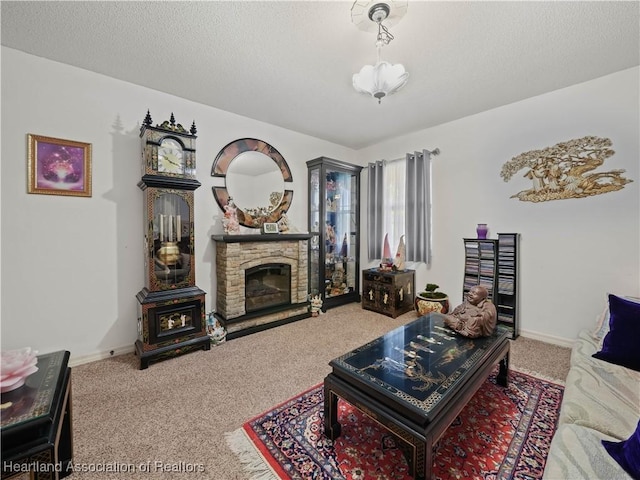 carpeted living area with baseboards, a stone fireplace, and a textured ceiling