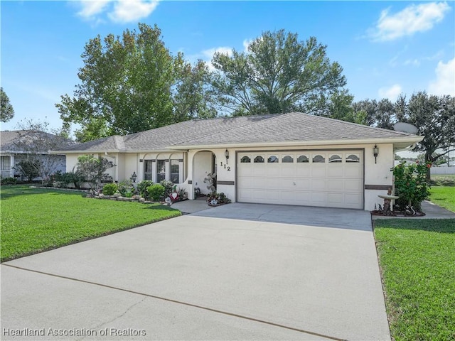 ranch-style house with a garage, driveway, a shingled roof, stucco siding, and a front yard